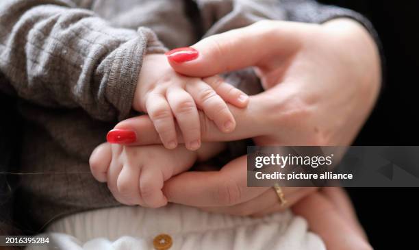 February 2024, Baden-Württemberg, Stuttgart: A woman holds a two-month-old baby in her arms. Photo: Bernd Weißbrod/dpa