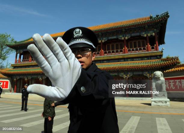 Chinese policeman blocks photos being taken outside Zhongnanhai which serves as the central headquarters for the Communist Party of China after the...
