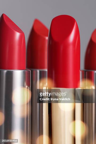 collection of  red  lipstick lip in golden silver glossy tube  on gray color background with sunlight blur effect. - silver lipstick stock pictures, royalty-free photos & images