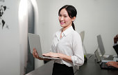 smiling businesswoman using laptop at office
