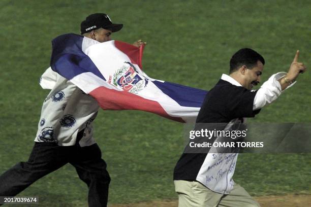 Two Dominican fans celebrate with their country's flag after the Dominican Republic team Aguilas de Cibao defeated the Mexican team 5 to 3 in the...