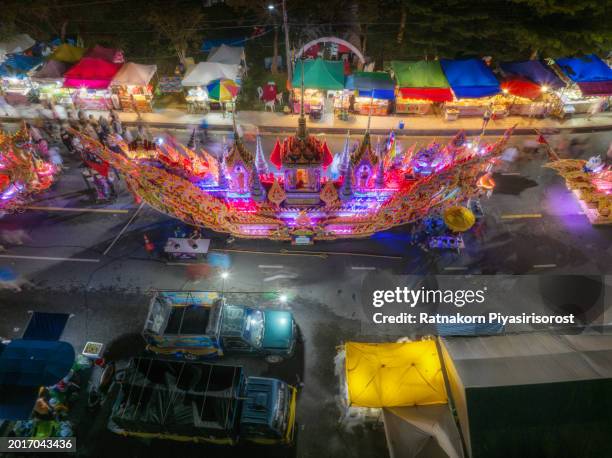 aerial drone event the cultural heritage of the boat race parade festival. people give alms to a buddhist monk with decorated boat parade along the road, songkhla, thailand - offspring culture tourism festival stock pictures, royalty-free photos & images