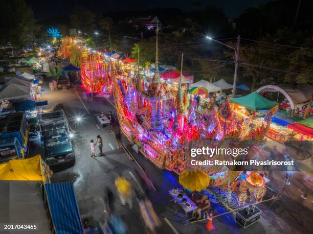 aerial drone event the cultural heritage of the boat race parade festival. people give alms to a buddhist monk with decorated boat parade along the road, songkhla, thailand - offspring culture tourism festival stock pictures, royalty-free photos & images