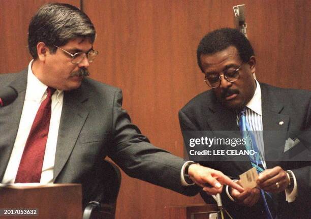Los Angeles Police Department Forensic Print Specialist, Gilbert Aguilar , points to a latent fingerprint lift card held by defense attorney Johnnie...