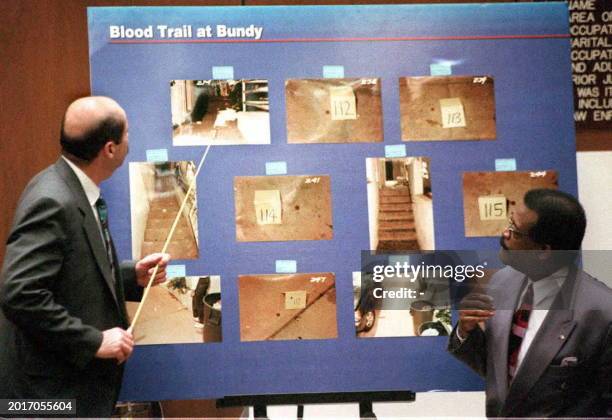 Los Angeles Police Detective Tom Lange points to pictures 06 March of the trail of blood at Nicole Brown Simpson's condominium where she and her...