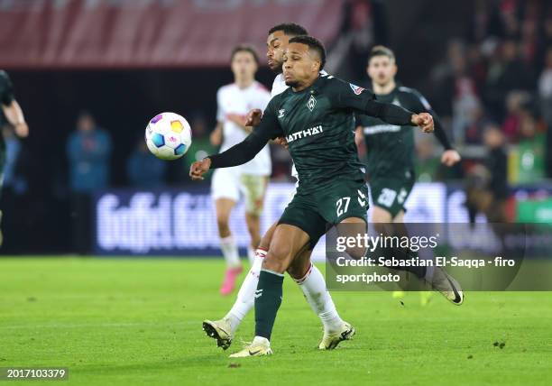 Felix Agu of SV Werder Bremen and Linton Maina of 1. FC Köln compete for the ball during the Bundesliga match between 1. FC Köln and SV Werder Bremen...