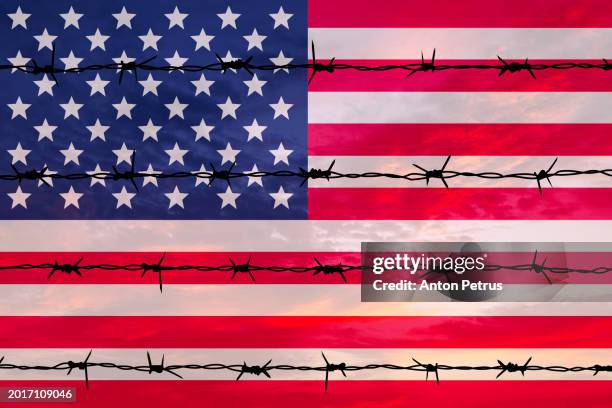 barbed wire on the background of the usa flag - auswanderung und einwanderung stock-fotos und bilder