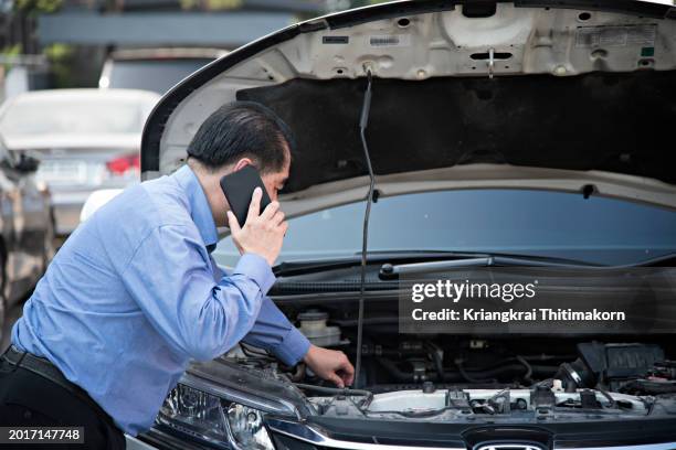 a car owner is calling a car repair shop to check condition of car. - engine failure stock pictures, royalty-free photos & images