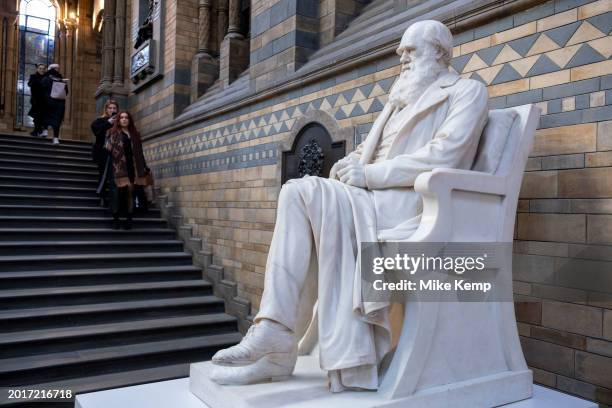 Visitors interact with the statue of English naturalist, geologist and biologist Charles Darwin at the Natural History Museum on 19th January 2024 in...