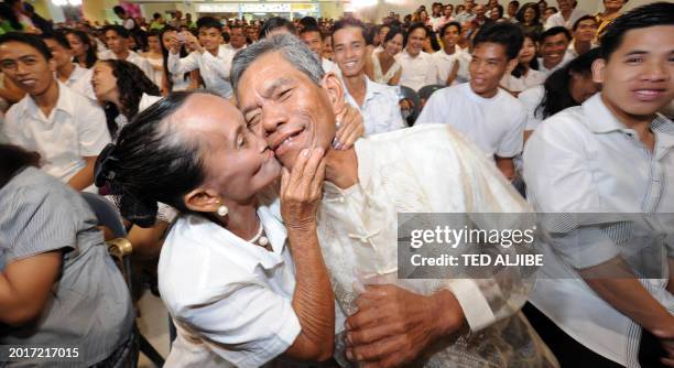 Elderly newly married couple Concepcion Elizalde and Nonilon kiss during a mass wedding as part of Valentine's Day celebrations at a shopping mall in...