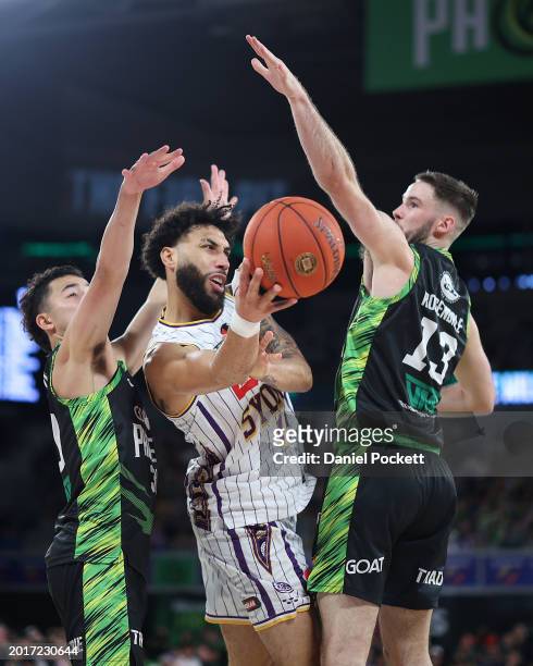 Denzel Valentine of the Kings passes the ball under pressure from Luke Rosendale of the Phoenix and Owen Foxwell of the Phoenix during the round 20...