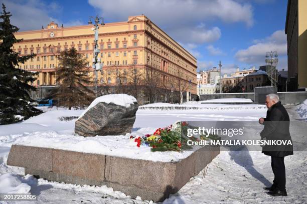 Man crosses himself as he comes to lay flowers for late Russian opposition leader Alexei Navalny at the Solovetsky Stone, a monument to political...