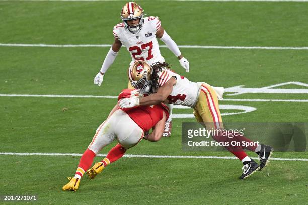 Travis Kelce of the Kansas City Chiefs gets tackled by Fred Warner of the San Francisco 49ers in overtime during Super Bowl LVIII at Allegiant...