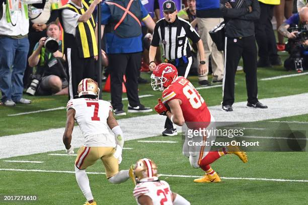 Travis Kelce of the Kansas City Chiefs runs with the ball pursued by Charvarius Ward of the San Francisco 49ers in the second half during Super Bowl...
