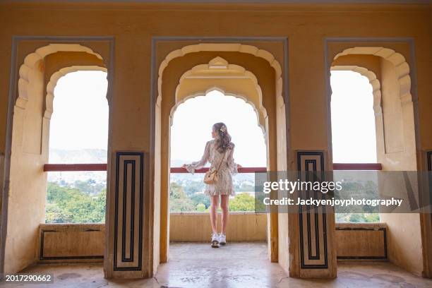 the baradhari pavilion in jaipur is situated at man singh palace square, and a young woman is standing in front of amber fort. - rambagh palace hotel stockfoto's en -beelden