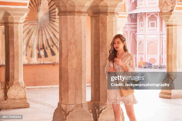 the baradhari pavilion in jaipur is situated at man singh palace square, and a young woman is standing in front of amber fort. - rambagh palace hotel stockfoto's en -beelden