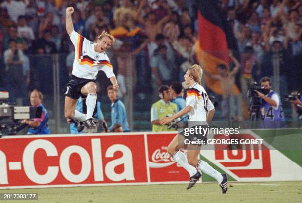 West German defender Andreas Brehme celebrates in front of forward Juergen Klinsmann after scoring the winning goal on a penalty kick during the...
