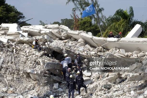 Rescuers work on the site of destroyed headquarter of the MINUSTAH in Port au Prince on January 17 five days after an earthquake majoring 7.0 only...