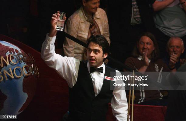 Ronnie O'Sullivan of England raises a glass to the cheering crowd after scoring a maximum 147 break during the first round of the Embassy World...