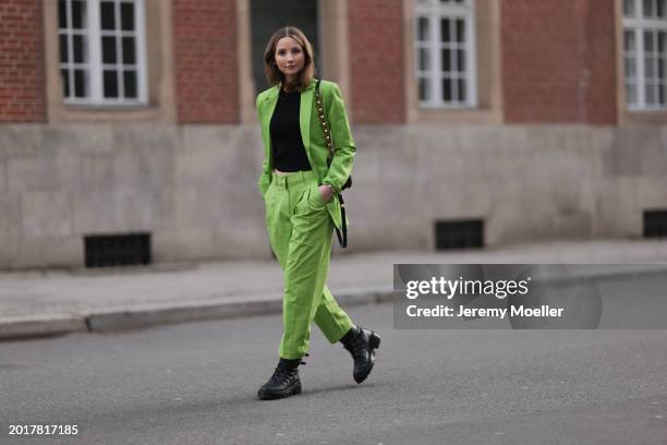 Anna Hiltrop seen wearing Michael Kors light green suit blazer jacket, matching Michael Kors light green suit long pants, black basic cotton top,...
