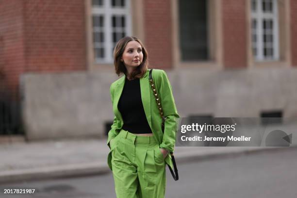 Anna Hiltrop seen wearing Michael Kors light green suit blazer jacket, matching Michael Kors light green suit long pants, black basic cotton top,...