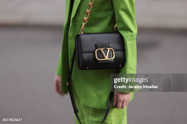 Anna Hiltrop seen wearing Michael Kors light green suit blazer jacket, matching Michael Kors light green suit long pants and Valentino Rockstud black...