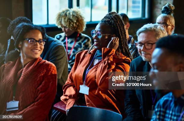 smiling group of multi racial business colleagues in audience at conference - launch event stock pictures, royalty-free photos & images