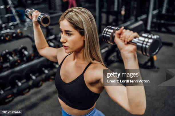 woman practicing with dumbbells in the gym - weight training stock pictures, royalty-free photos & images