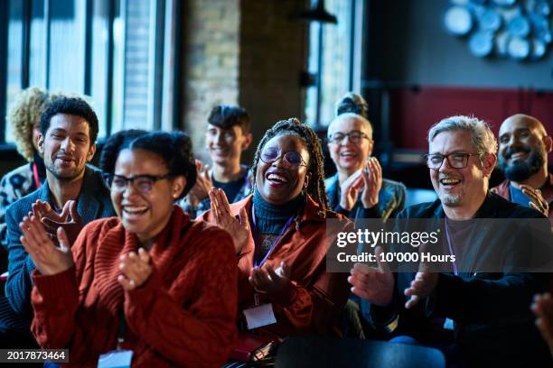 audience of happy multi racial co-workers applauding at business conference - centro congressi foto e immagini stock