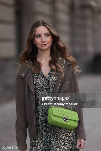 Anna Hiltrop seen wearing Boss green / beige / black print pattern pleated long dress, Boss brown suede leather jacket, Michael Kors green leather...