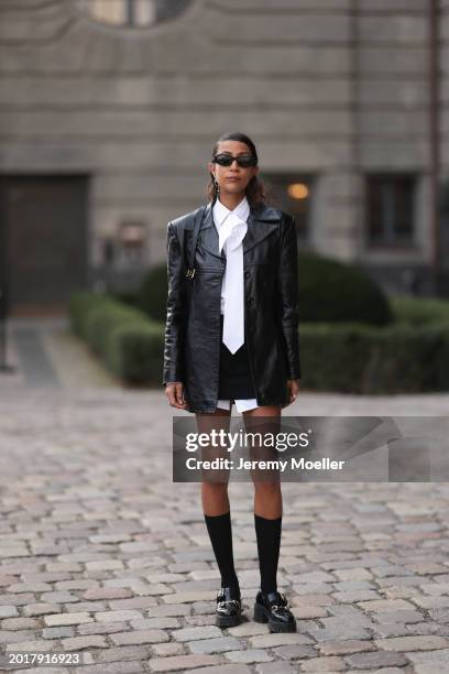 Rabea Schif seen wearing Prada black oval shaped sunglasses, Chanel gold earrings, Vintage black leather jacket, Peter Petrov black short skirt,...