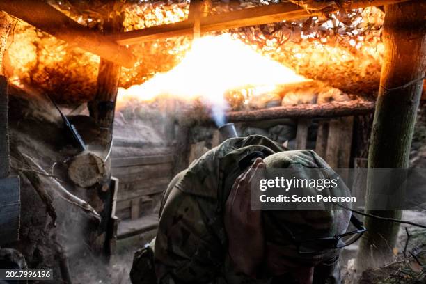 Ukrainian soldier with the nickname Yakut covers his ears as a 120mm mortar blasts from its tube, as soldiers of the 1st Presidential Brigade of the...