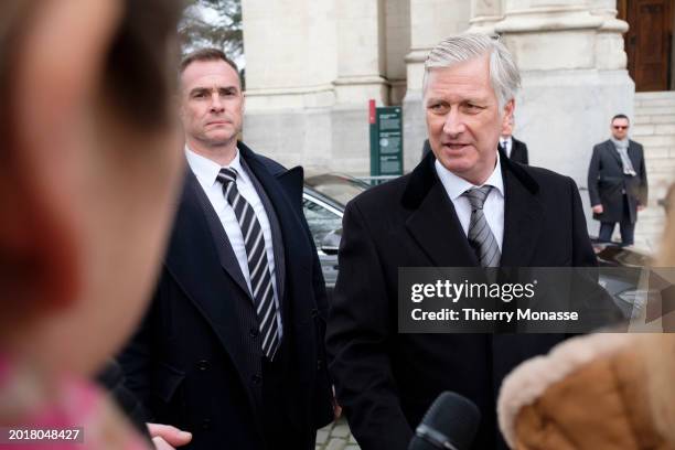 King Philippe of Belgium is looking at a drawing at the end of the annual mass at the Notre-Dame church in Laeken, in memory of the deceased members...