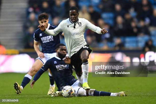 Djeidi Gassama of Sheffield Wednesday is tackled by Japhet Tanganga of Millwall during the Sky Bet Championship match between Millwall and Sheffield...