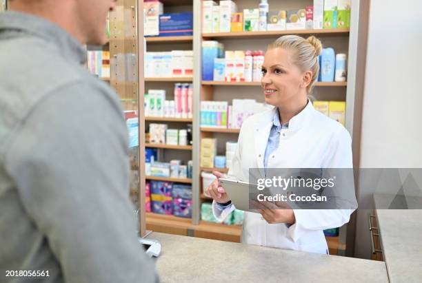 female pharmacist serving the customer, using digital tablet to check the prescription - coco stock pictures, royalty-free photos & images