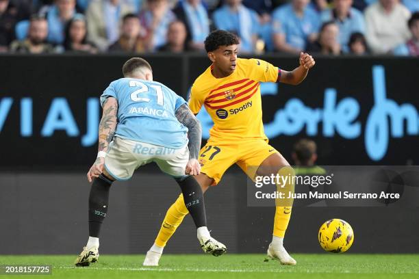 Lamine Yamal of FC Barcelona is challenged by Mihailo Ristic of Celta Vigo during the LaLiga EA Sports match between Celta Vigo and FC Barcelona at...