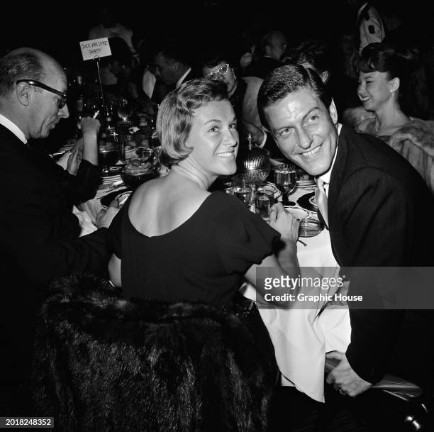 American actor and comedian Dick Van Dyke and his wife, Margie, turning as they sit at their table at the Cocoanut Grove, at the Ambassador Hotel in...