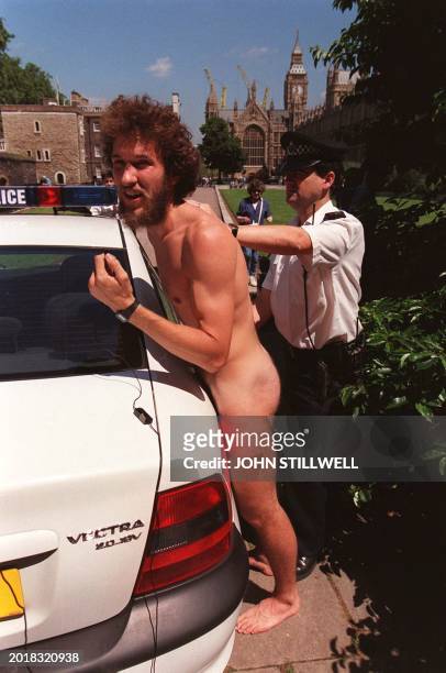 Naked protestor is arrested by a police officer outside the Houses of Parliament in London this Wednesday, 24 June 1998, following a demonstration by...