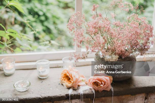beautiful vintage table with mirror, roses, flowers and candles in living room or bedroom. loft, botanic, rustic style. - decorating loft ストックフォトと画像