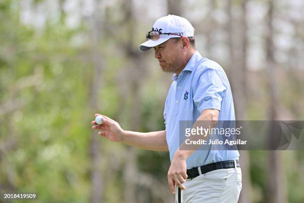 Charlie Wi of the United States waves to fans after putting on the fourth green during the second round of the Chubb Classic at Tiburon Golf Club on...