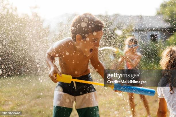 wasserschlacht in unserem hinterhof - kinderspiele stock-fotos und bilder