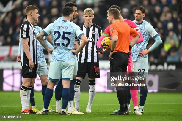 Referee Michael Salisbury talks to Anthony Gordon and the players as they await the Penalty VAR decision during the Premier League match between...