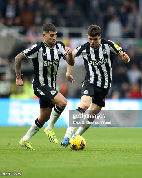 Lewis Miley of Newcastle United runs with the ball with teammate Bruno Guimaraes during the Premier League match between Newcastle United and AFC...