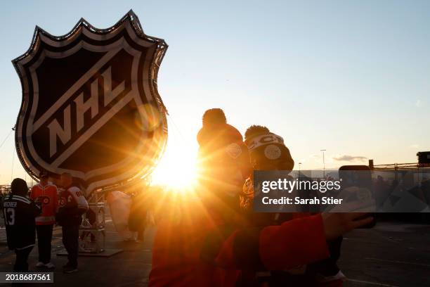 Fans take a "selfie" near the NHL logo ahead of the 2024 Navy Federal Credit Union Stadium Series game between the Philadelphia Flyers and the New...