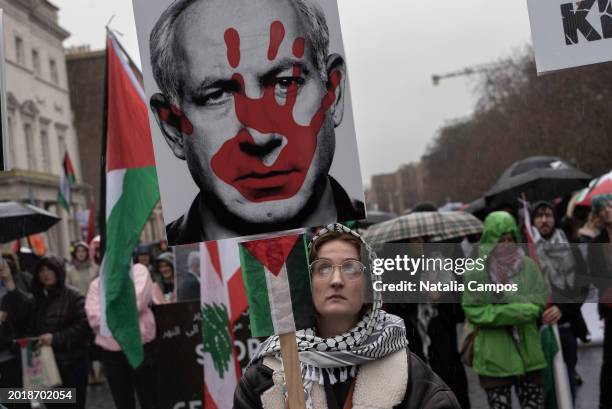 Female protester raise a placard with a depiction of a red hand on the face of Benjamin Netanyahu during a protest held by the Ireland-Palestine...