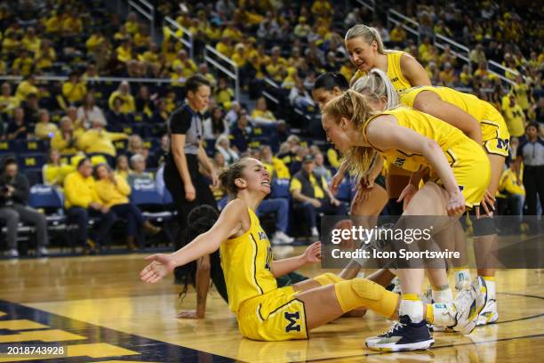 Michigan Wolverines guard Jordan Hobbs , left, reacts to drawing a charging foul as her teammates help her get up off of the court during a regular...