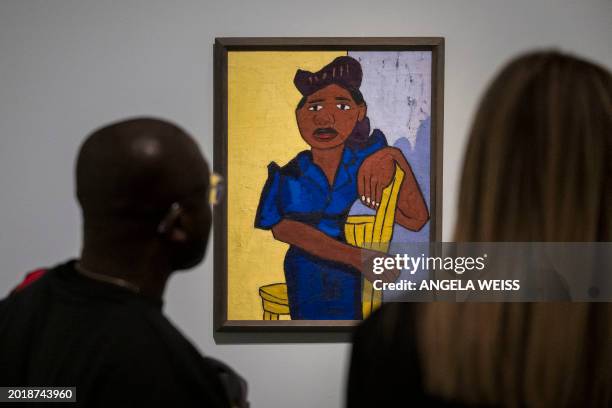 People look at a painting by William H. Johnson titled "Woman in Blue" during a press preview of "The Harlem Renaissance and Transatlantic Modernism"...