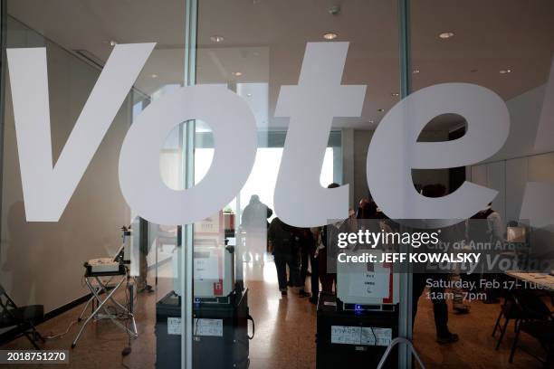 People cast their ballots during early voting in the state's primary on the campus of the University of Michigan in Ann Arbor, Michigan on February...