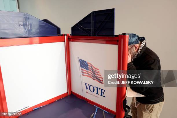 People cast their ballots during early voting in the state's primary on the campus of the University of Michigan in Ann Arbor, Michigan on February...