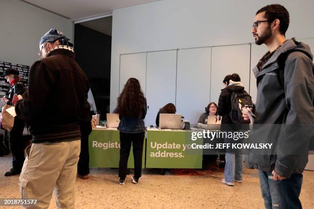 People cast their ballots during early voting in the state's primary on the campus of the University of Michigan in Ann Arbor, Michigan on February...